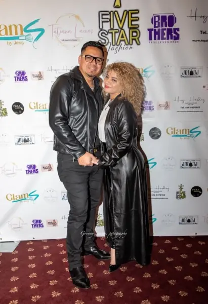 Selvin and Elvia, founders of Urban News, smiling together in front of a city skyline, embodying the spirit of their news platform.